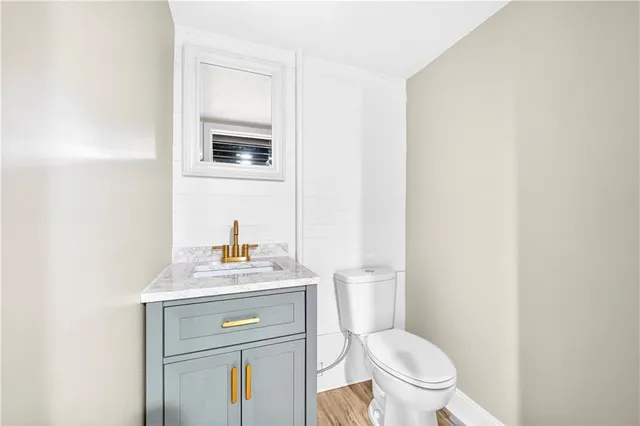 a bathroom with a toilet a sink and mirror