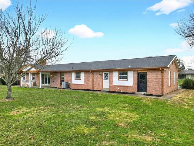 a front view of a house with a yard and trees