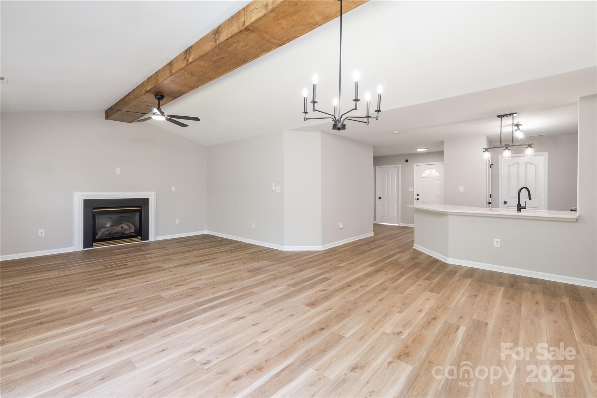 181 Mott Road Mooresville, NC 28115 - Photo 14 of 26 a view of a kitchen with a sink dishwasher and a fireplace with wooden floor