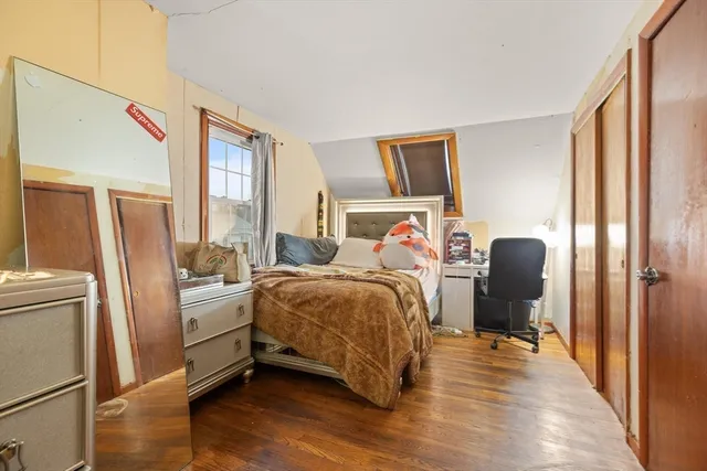 a bedroom with a bed and wooden floor