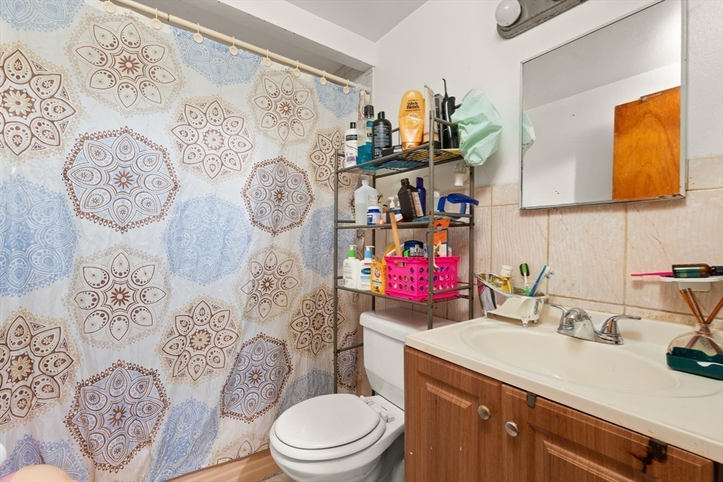 115 Windham Road Boston, MA 02136 - Photo 14 of 30 a bathroom with a granite countertop toilet sink and mirror