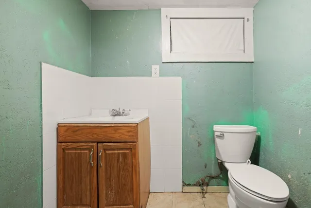 a bathroom with a toilet sink and mirror
