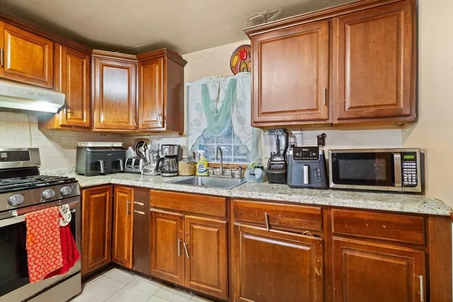 a kitchen with stainless steel appliances granite countertop wooden cabinets a sink and a window