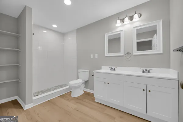 an empty room with chandelier fan and windows