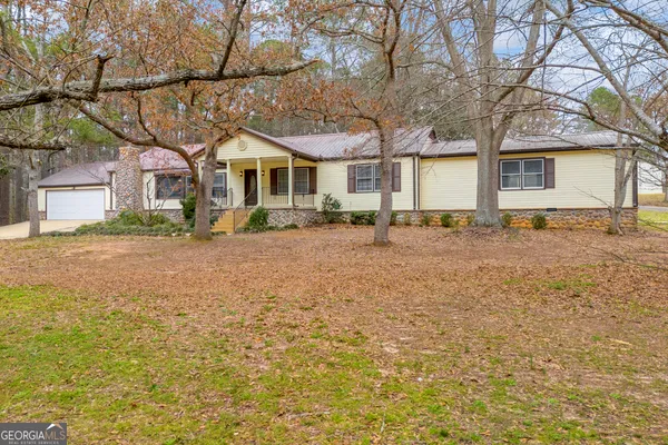 a front view of a house with a yard and trees