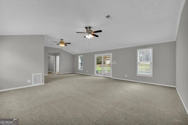 an empty room with windows and fireplace