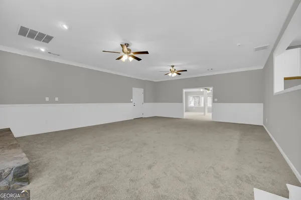 a view of a livingroom with a ceiling fan and window