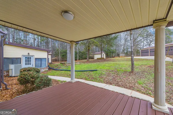 a view of house with backyard and trees in the background