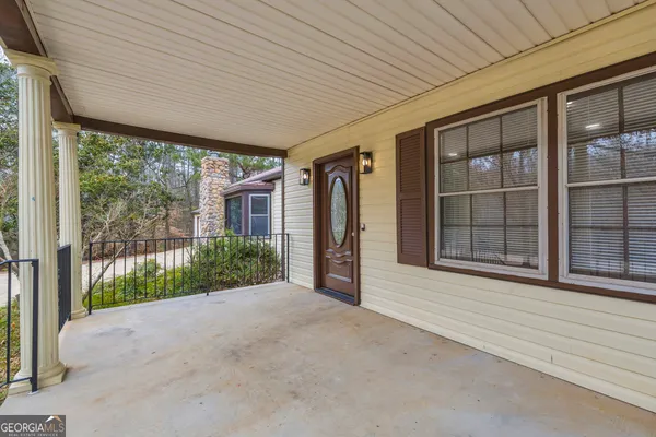 a view of an empty room with wooden floor and windows