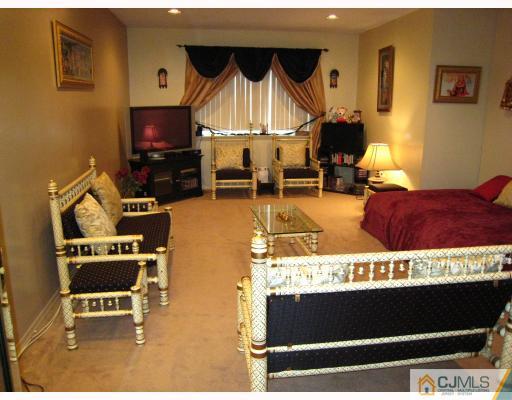 5207 Hana Road Edison, NJ 08817 - Photo 2 of 10 a living room with furniture a flat screen tv and a fireplace