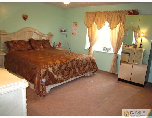5207 Hana Road Edison, NJ 08817 - Photo 7 of 10 a bed sitting in a bedroom next to a window