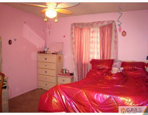 5207 Hana Road Edison, NJ 08817 - Photo 8 of 10 a bedroom with a bed and a dresser