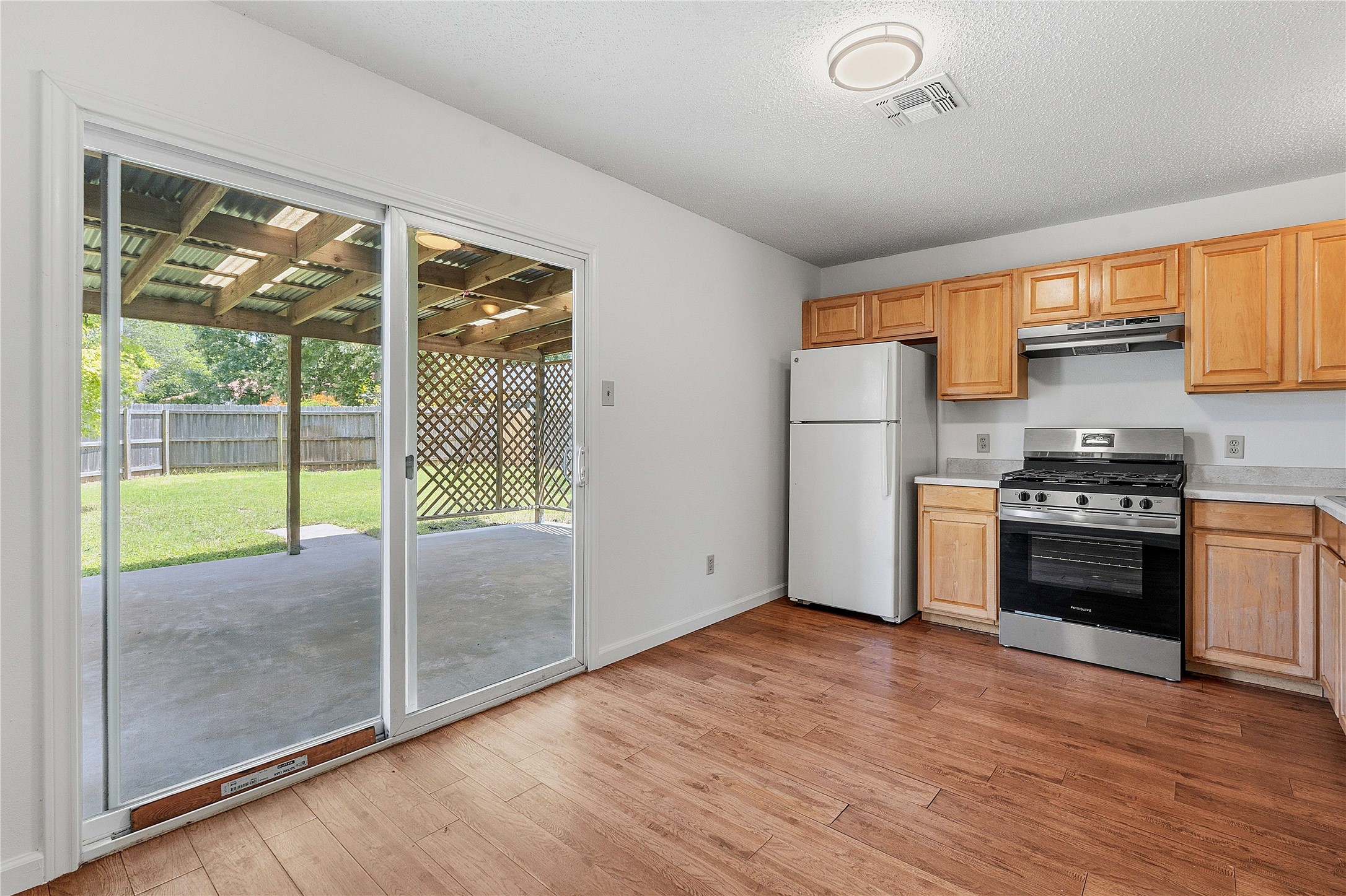 6205 Shadow Bend Austin, TX 78745 - Photo 13 of 31 Wood flooring brightens this kitchen with sliding doors to a private yard and covered patio.