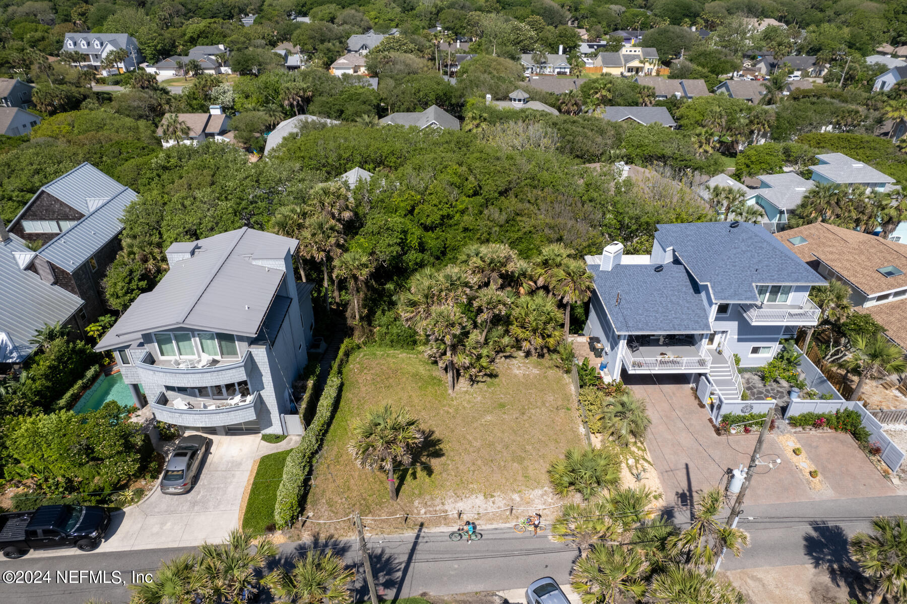 an aerial view of a residential houses with outdoor space and parking
