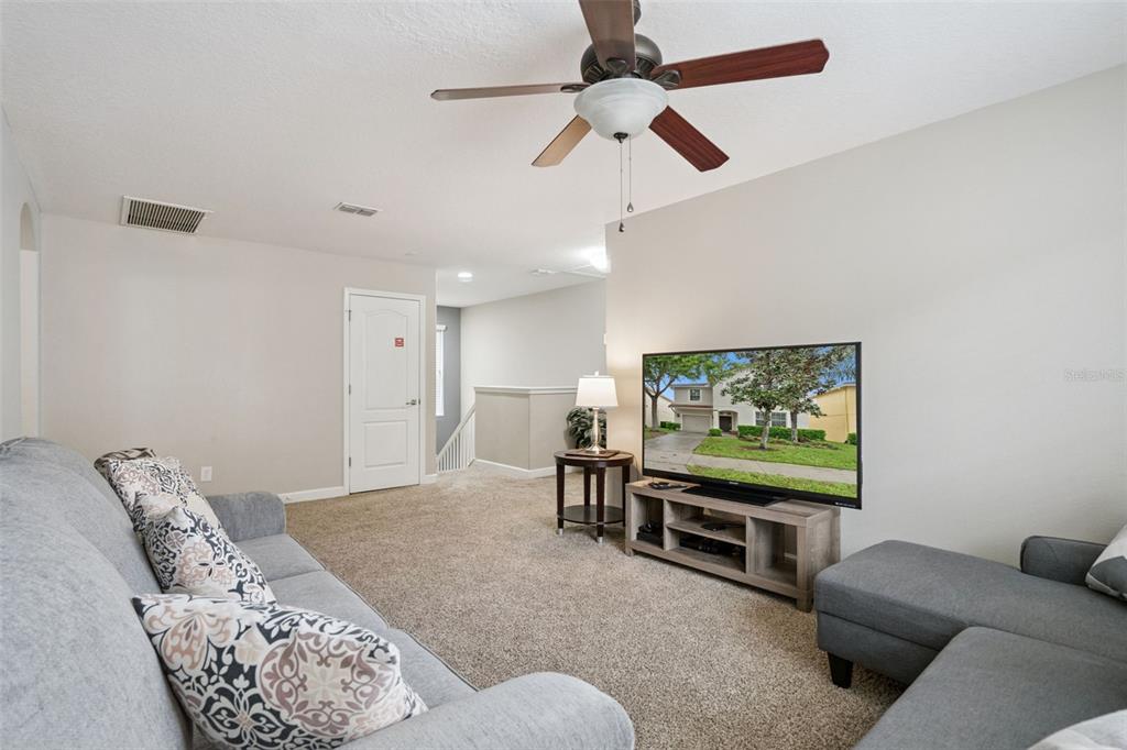 8965 Cuban Palm Road Kissimmee, FL 34747 - Photo 13 of 77 a living room with furniture and a flat screen tv