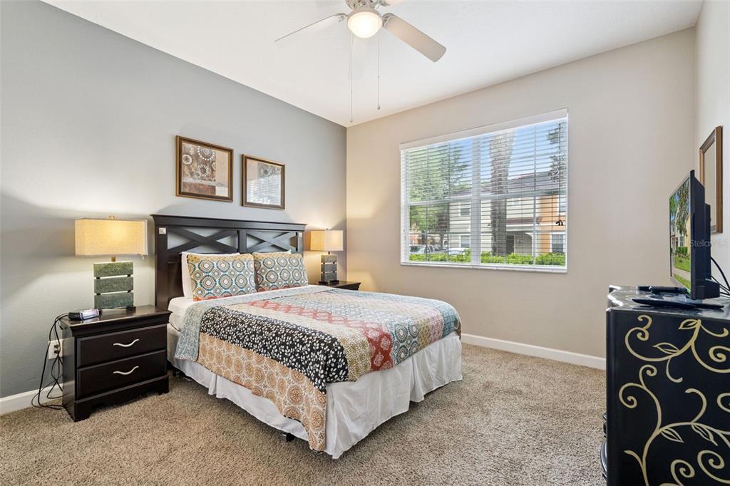 8965 Cuban Palm Road Kissimmee, FL 34747 - Photo 15 of 77 a bedroom with a bed and a flat tv screen on a dresser