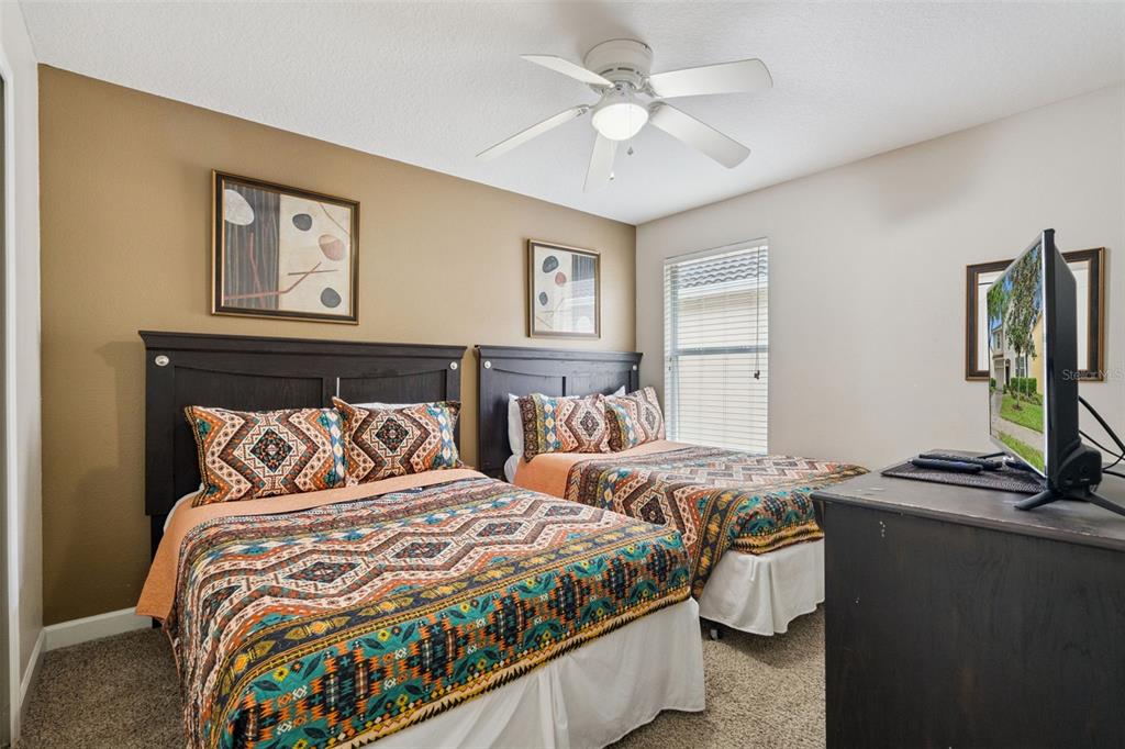 8965 Cuban Palm Road Kissimmee, FL 34747 - Photo 20 of 77 a bedroom with 2 bed and a chandelier