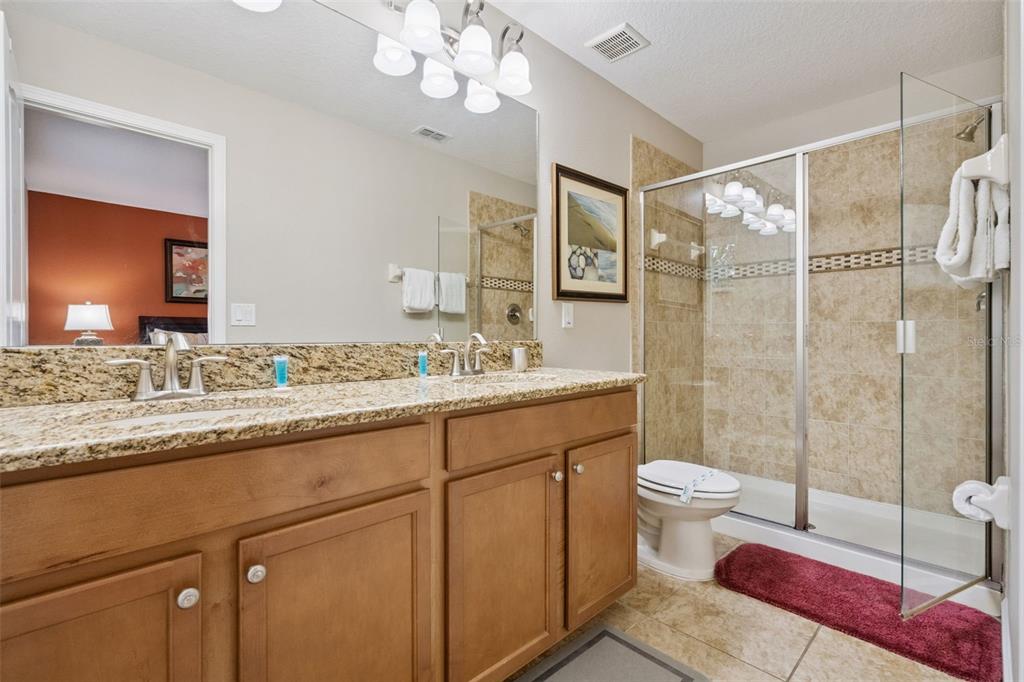 8965 Cuban Palm Road Kissimmee, FL 34747 - Photo 23 of 77 a bathroom with a granite countertop sink a toilet and shower