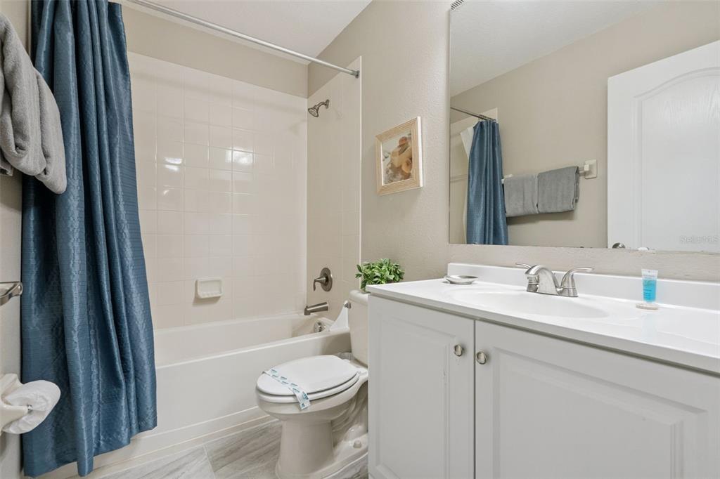 8965 Cuban Palm Road Kissimmee, FL 34747 - Photo 25 of 77 a bathroom with a toilet a sink a tub and mirror