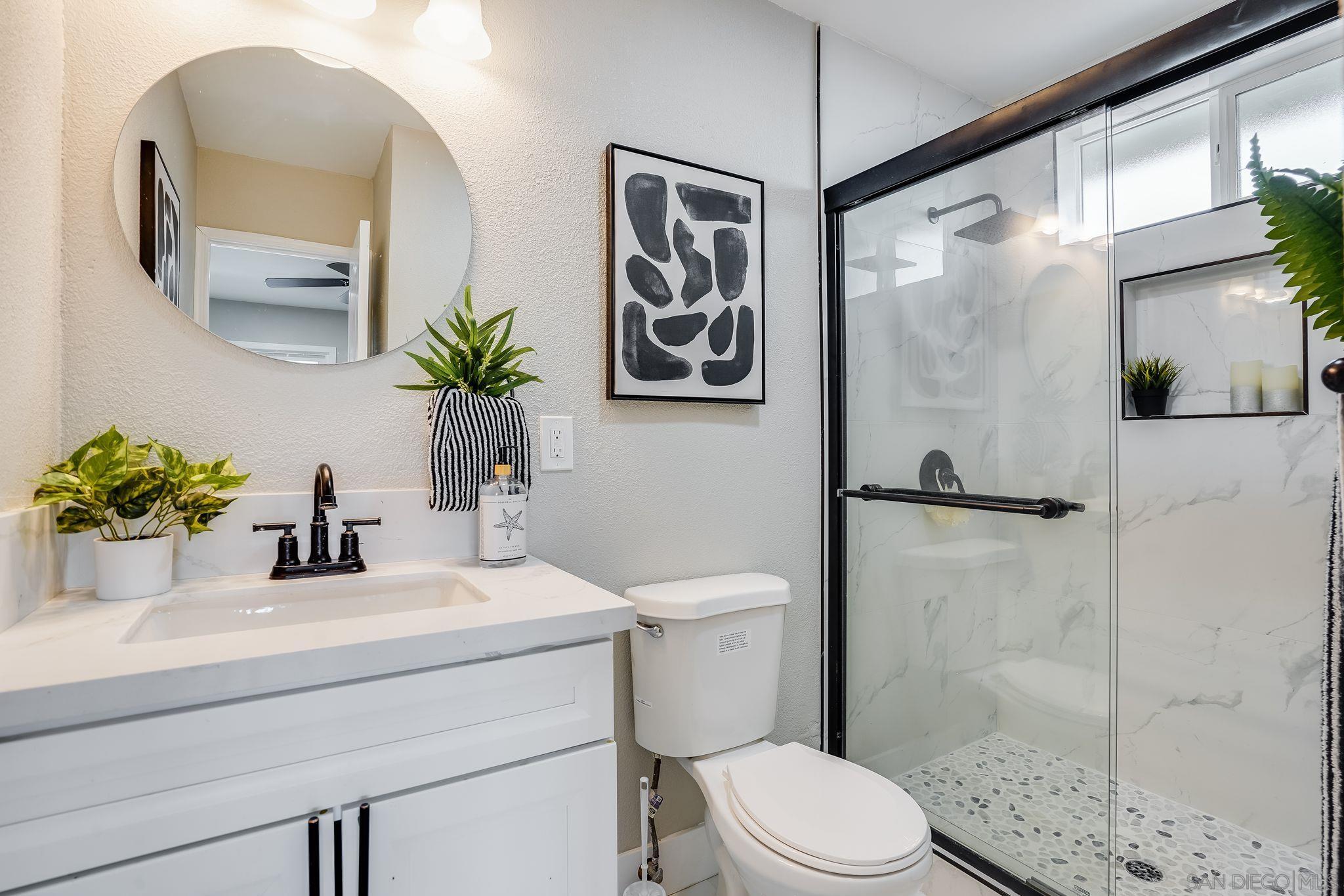 3350 Watercrest Court Bonita, CA 91902 - Photo 17 of 27 a bathroom with a sink a toilet a glass door a shower and a mirror