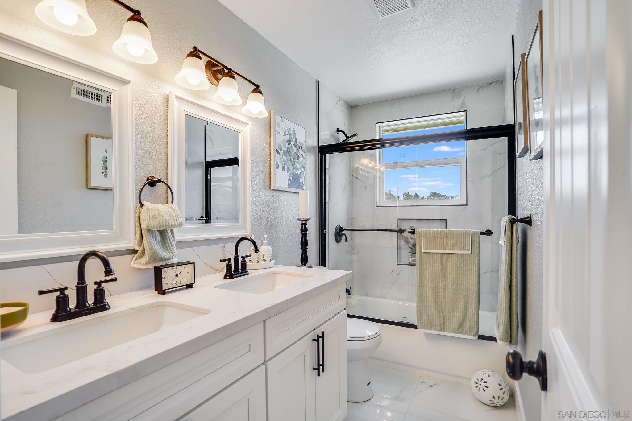 3350 Watercrest Court Bonita, CA 91902 - Photo 21 of 27 a bathroom with a double vanity sink a toilet and a mirror