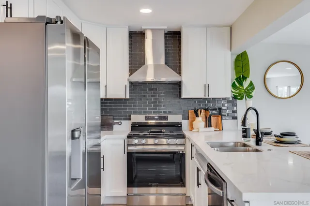 a kitchen with stainless steel appliances granite countertop a stove a sink and a refrigerator