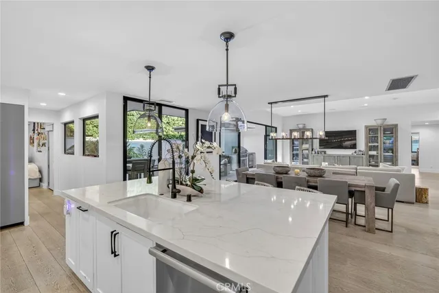 a large kitchen with kitchen island a large counter top space a sink and appliances