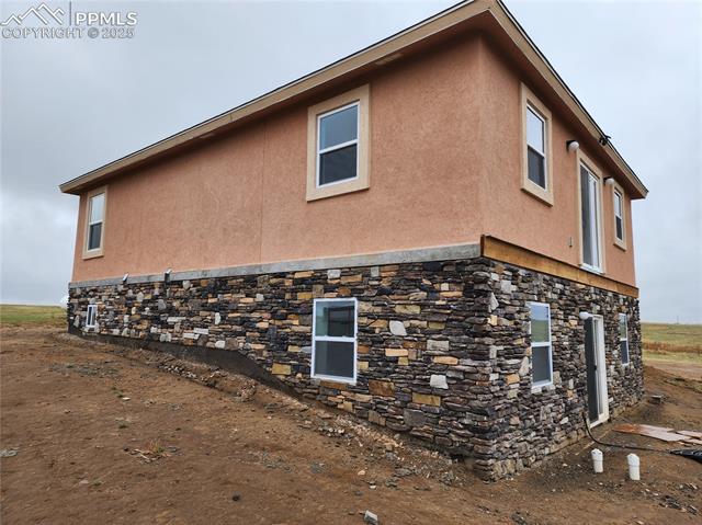 32174 Torrence Road Yoder, CO 80864 - Photo 4 of 13 View of property exterior with stone siding and stucco siding
