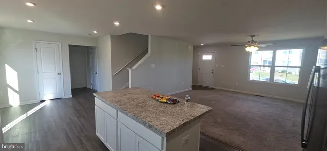 a kitchen with stainless steel appliances granite countertop cabinets wooden floor and a window