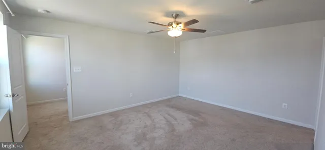 an empty room with a chandelier fan