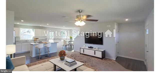 a living room with furniture a flat screen tv and kitchen view