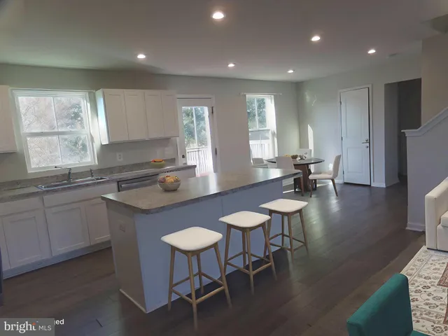 a kitchen with a table chairs sink and cabinets