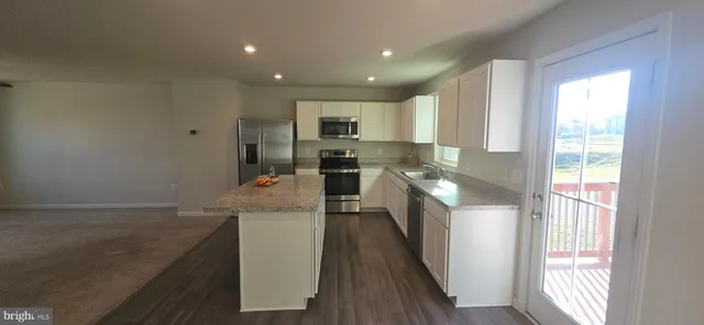 a kitchen with a sink a counter top space stainless steel appliances and a window