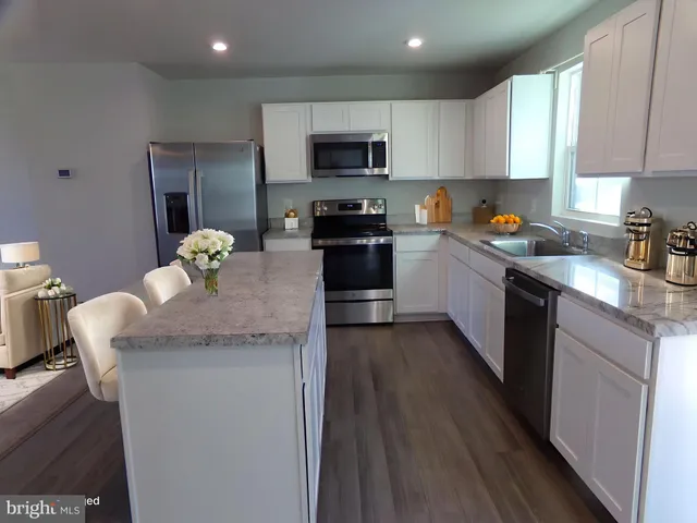 a kitchen with granite countertop stainless steel appliances and wooden cabinets
