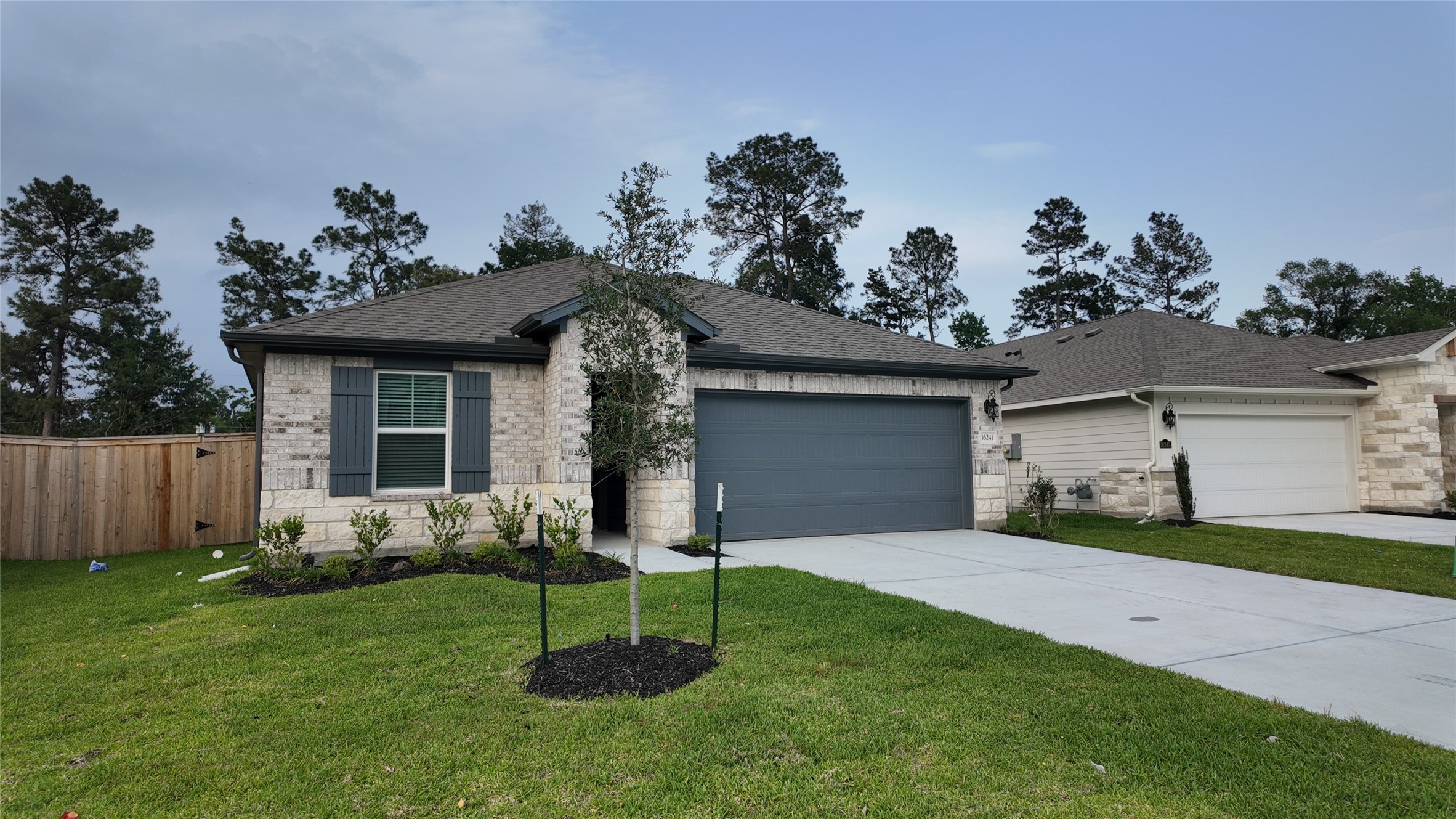 16241 Parish Pointe Court Conroe, TX 77302 - Photo 2 of 25 a view of a house with a yard and a garden