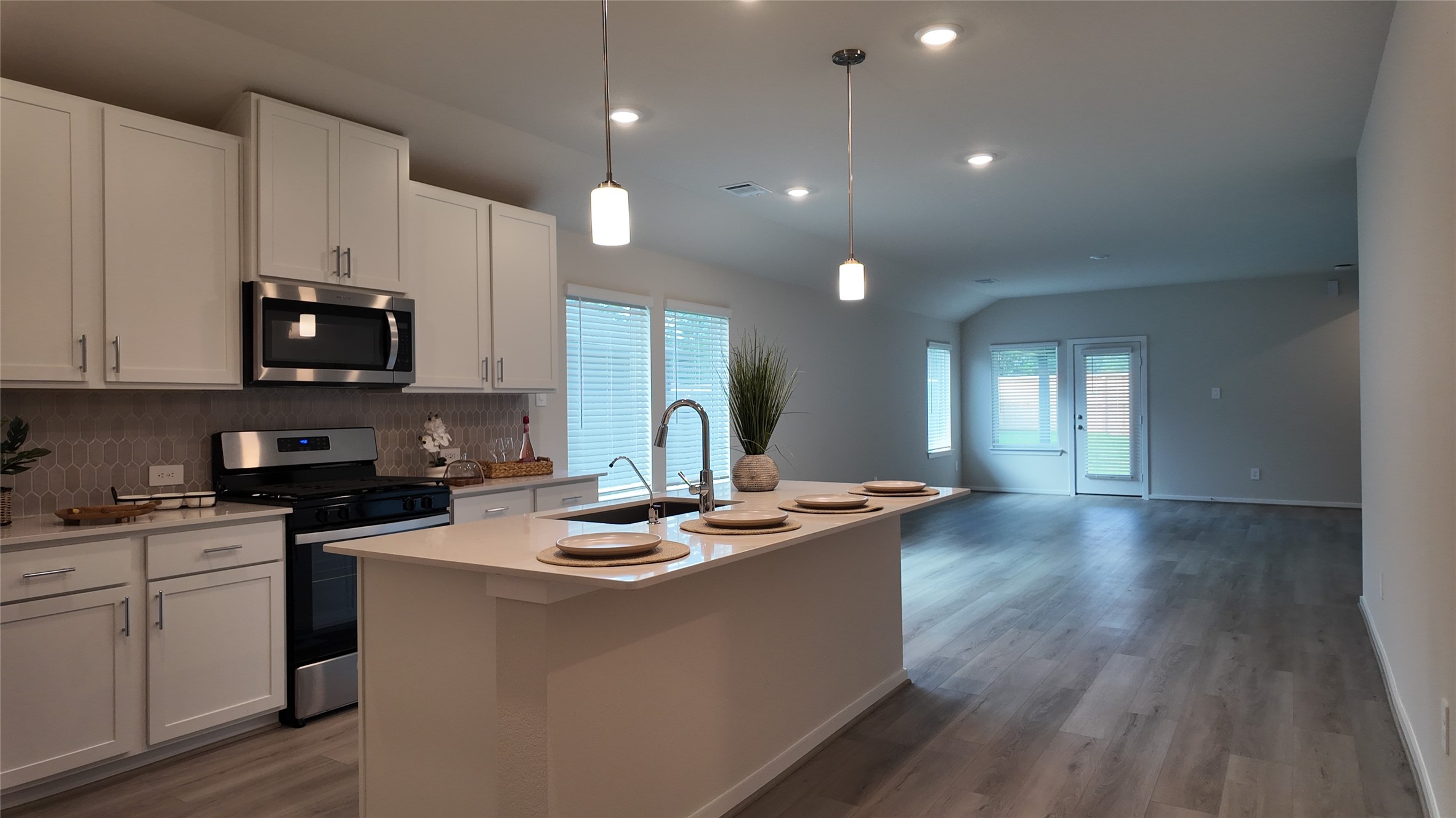 16241 Parish Pointe Court Conroe, TX 77302 - Photo 6 of 25 a kitchen with stainless steel appliances kitchen island granite countertop a stove a sink and a microwave
