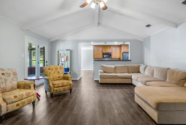 a living room with furniture and a wooden floor
