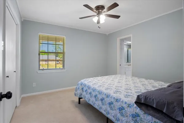 a bedroom with a bed chandelier and a window