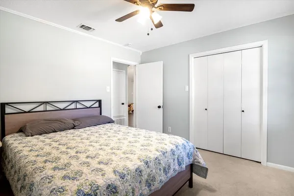 a bedroom with a large bed and a chandelier