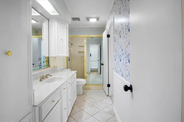 a spacious bathroom with a double vanity sink a toilet a shower and a mirror