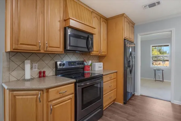 a kitchen with stainless steel appliances granite countertop a stove microwave and cabinets