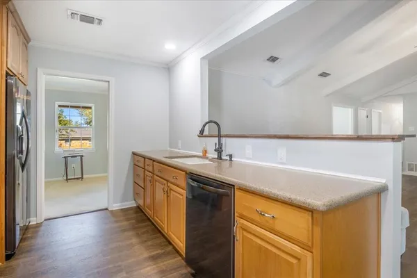 a kitchen with stainless steel appliances granite countertop a sink and dishwasher with wooden floor