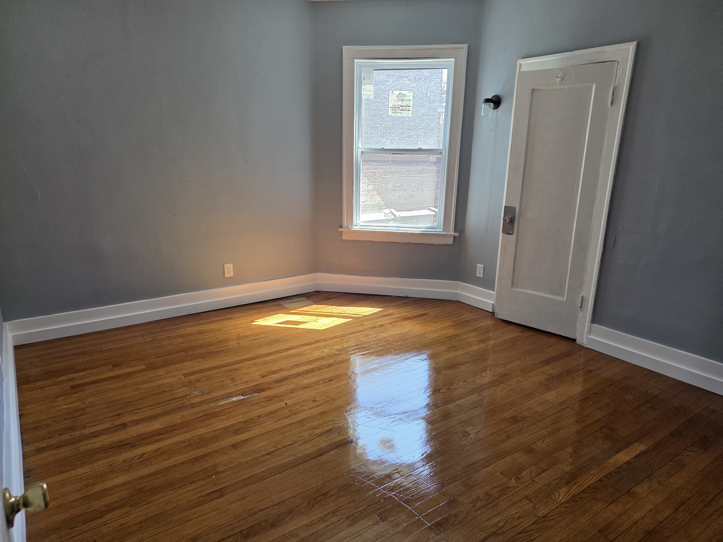 1853 East 79th Street, Unit 2 Chicago, IL 60649 - Photo 7 of 14 a view of empty room with window and wooden floor
