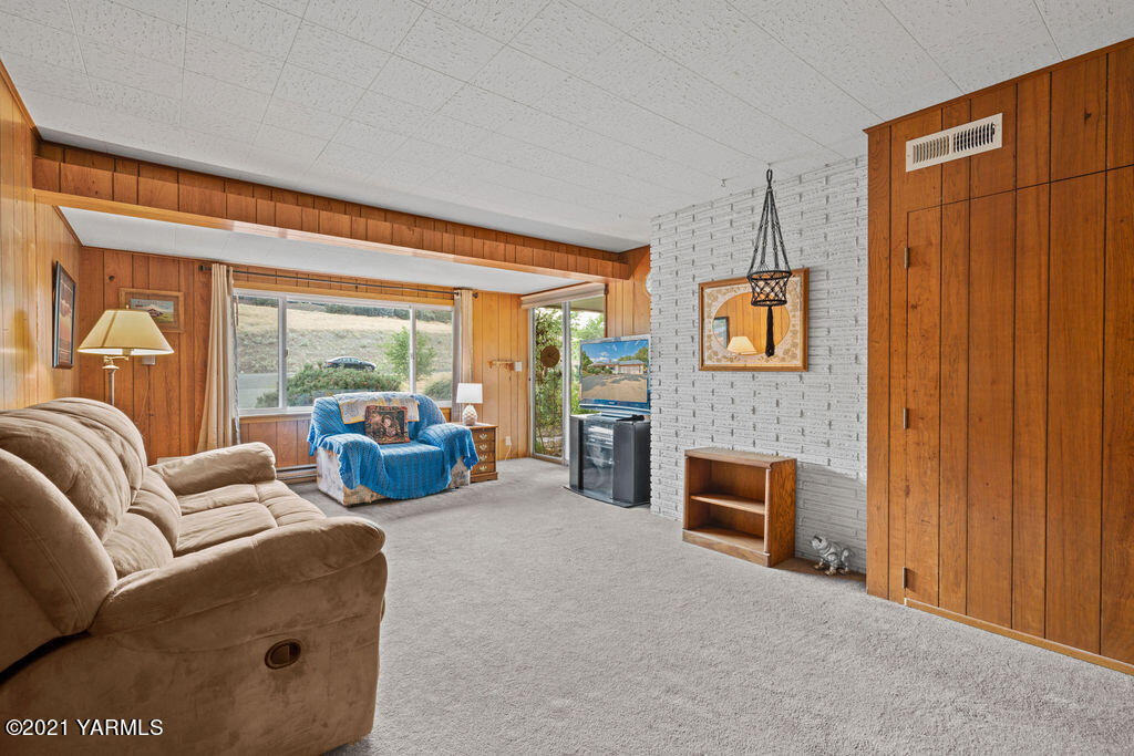 11417 Summitview Road Yakima, WA 98908 - Photo 16 of 26 a living room with furniture a fireplace and a floor to ceiling window