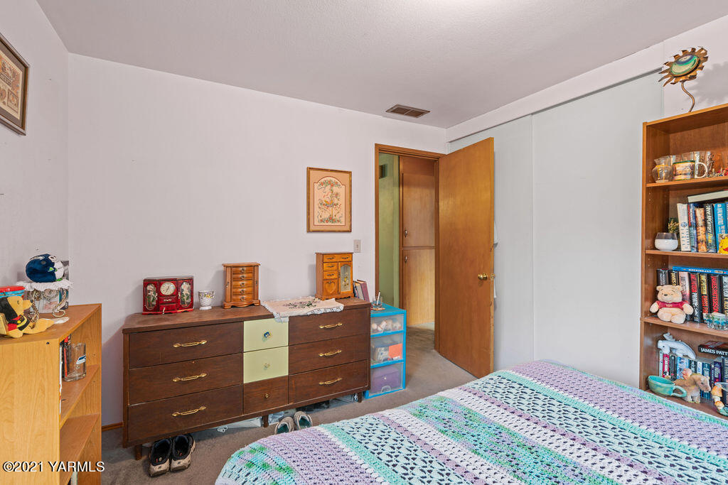 11417 Summitview Road Yakima, WA 98908 - Photo 20 of 26 a bedroom with a bed and book shelf