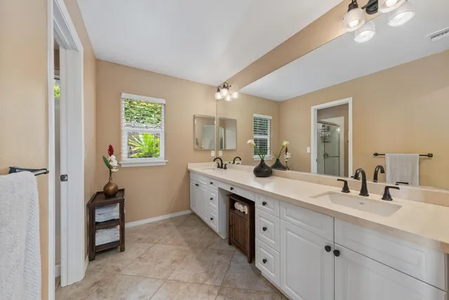 a spacious bathroom with a double vanity sink a mirror and a bathtub