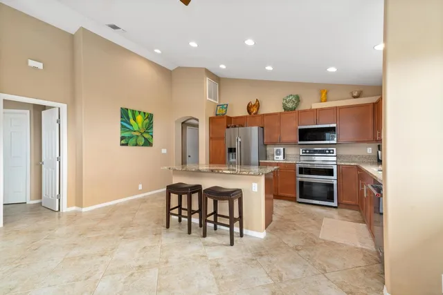 a kitchen with kitchen island stainless steel appliances a stove a sink a counter top space and cabinets