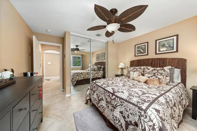 a spacious bedroom with a bed a chandelier and a mirror