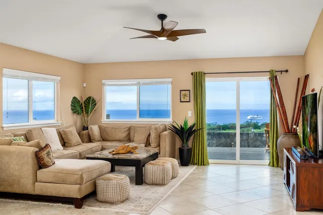 a living room with furniture a flat screen tv and a large window