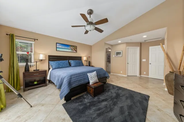 a spacious bedroom with a bed and ceiling fan